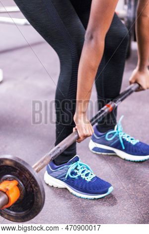 A High School Female Wearing Spandex In The Weight Room Lifitng A Barbell With Weights Off The Groun