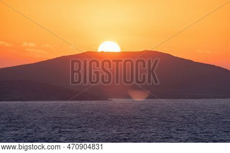 Rocky Island On Mediterranean Sea. Rinia Near Mikonos, Greece, Europe. Nature Background. Sunrise Sk