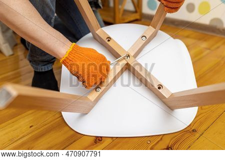 Self-assembly Furniture Concept. The Young Man Himself Assembling Chairs