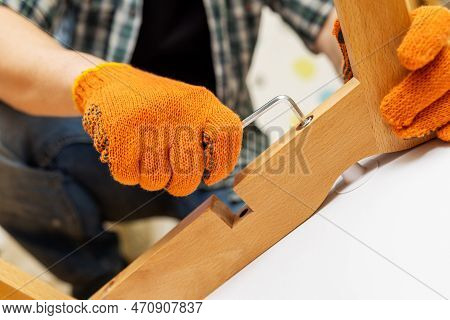 Self-assembly Furniture Concept. The Young Man Himself Assembling Chairs