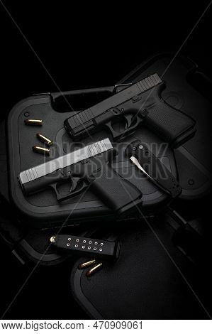 Two Pistols, 9mm Cartridges And A Penknife Lie On A Plastic Gun Case. Self-defense And Survival Kit.