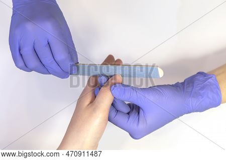 Manicurist Shapes, Files Beautiful Womans Nails, Holding Finger. Caucasian Manicure Master Works In 