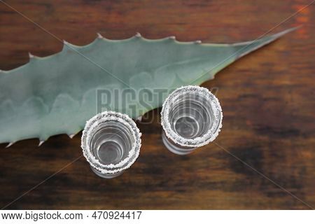 Mexican Tequila Shots With Salt And Green Leaf On Wooden Table, Top View. Drink Made Of Agava