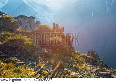 Colorful Mountain Scenery On Abyss Edge With Sharp Stones Among Green Flora In Sunlight. Sunny View 