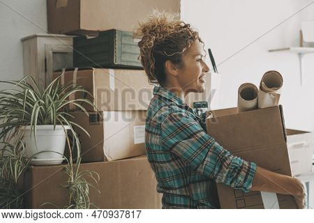Happy Adult Woman Relocating House Lifting Cardboard Box With Life Stuffs. New Beginnings Emotion. L