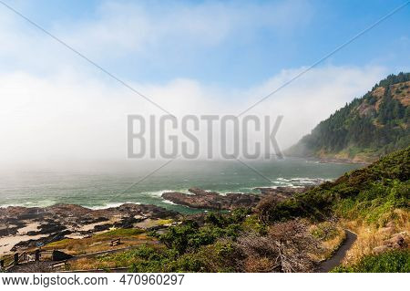 Scenic View Of Rocky Beach Near Town Of  Yatchats, With People On The Beach, Oregon, Usa