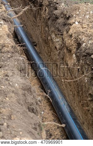 Plastic Sewer Pipe In Trench For Laying An External Sewage System At A Construction Site.