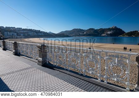 Walking On Promenade Along White Sandy La Concha Beach In Central Part Of Donostia Or San Sebastian
