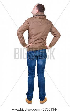 Back view of handsome man in brown windcheater looking up.   Standing young guy in jeans. Rear view people collection.  backside view of person.  Isolated over white background.
