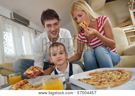 happy young family eating tasty pizza with cheesa and dring healthy and fresh orange juice