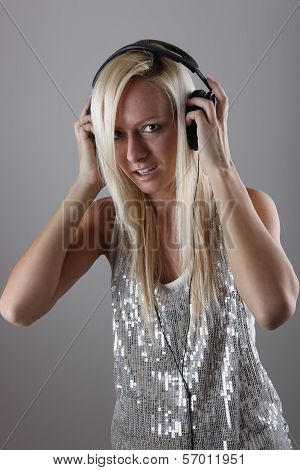 Girl with headphones at the party in shiny dress