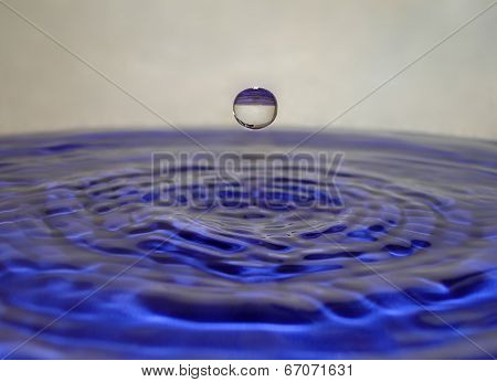 Falling water drop above water level