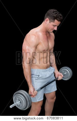 Focused crossfitter lifting up heavy barbell on black background