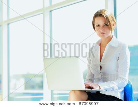 Young woman sitting with laptop computer