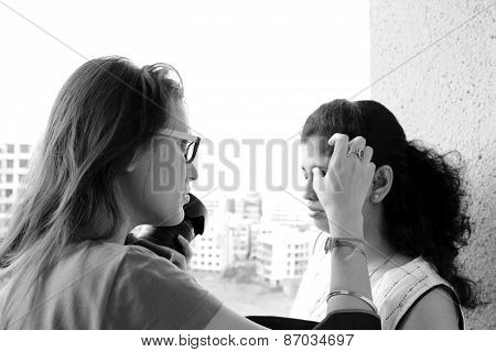 Indian photographer retouching makeup of the model holding camera in hand