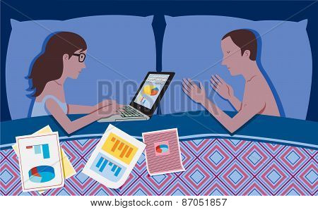 Woman works in bed at night while her partner is sleeping