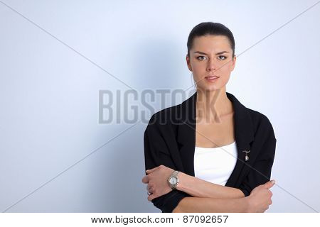A young woman standing, isolated on graybackground