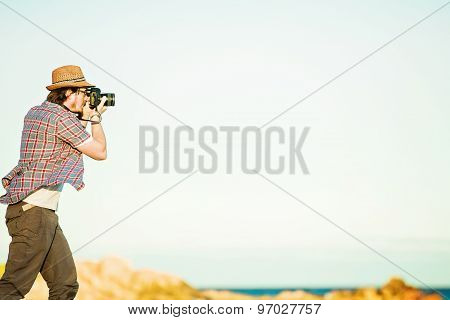 Young photographer taking photos at the beach