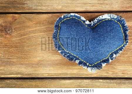 Denim heart on wooden background