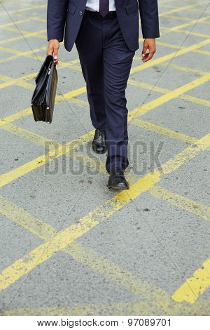 Businessman in suit walking down trottoire