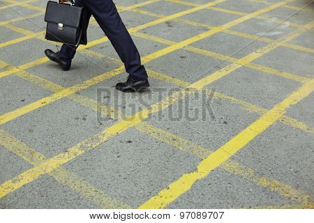 Modern businessman in formalwear walking down trottoire