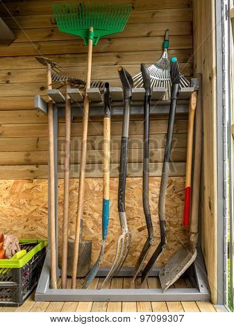 Wooden rack with different garden tools and equipment