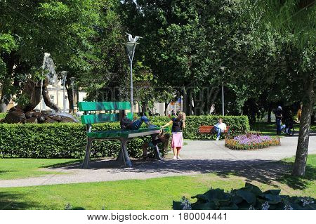 OREBRO, SWEDEN - JULY 7, 2016: Unidentified people rest in the Henry Allard Park at a giant bench.