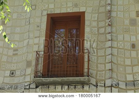 foreground of a balcony on a facade decorated with crochet work