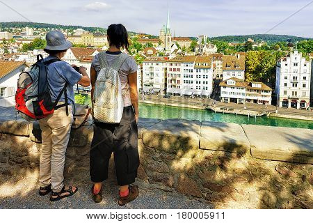 Two Female Tourists Backpackers Looking At Limmatquai Zurich