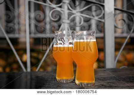 Two glasses of beer on a table in a street cafe, selective focus