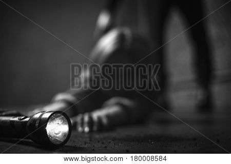 A few more inches. Quick witted trapped young woman looking for some kind of weapon for protecting herself and reaching for a flashlight