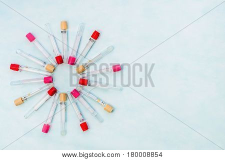 Test tubes for laboratory diagnosis blood tests on a blue background.Tubes are located in the form of rays or flower petals