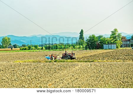 Tractor doing agricultural work in the field Austria in summer.