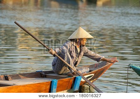 Hoi An Vietnam - February 20 2017 - The boatwoman  on the old national vietnamese boat down the Thu Bong river.