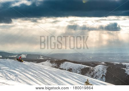 Rider on the snowmobile in the mountains ski resort in Amut Russia.