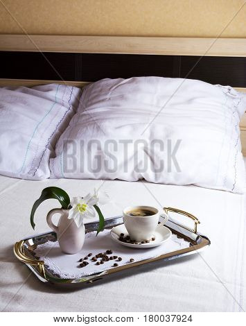 Cup of morning coffee on elegant silver serving tray. Hotel service concept.