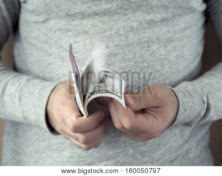 Hands counting dollars. Selective focus. Shallow DOF