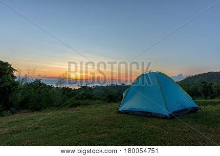 Tourist tent in camp among meadow in the mountain at sunrise