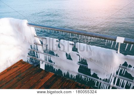 Snow and ice on the sea promenade. Icing seaside promenade after a strong winter storm with heavy frost.water