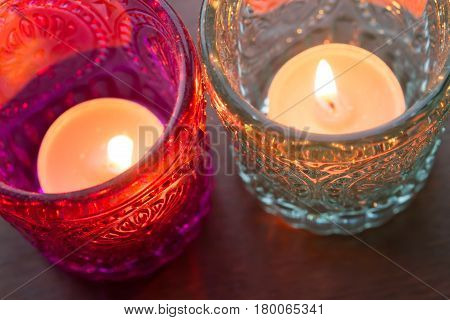 pink candle and light blue candle on a table .