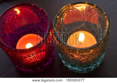 pink candle and light blue candle on a table .