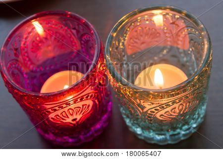 pink candle and light blue candle on a table .