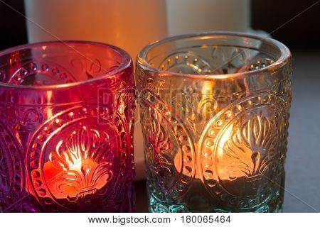 pink candle and light bule candle on a table .