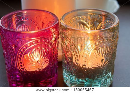 pink candle and light bule candle on a table .