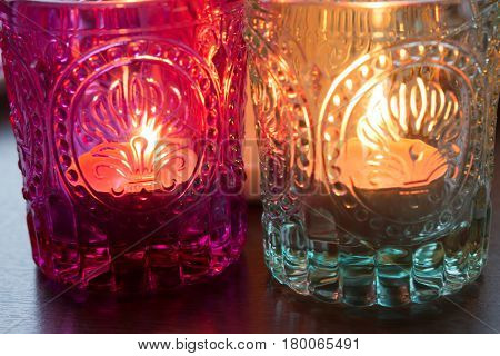 pink candle and light bule candle on a table .