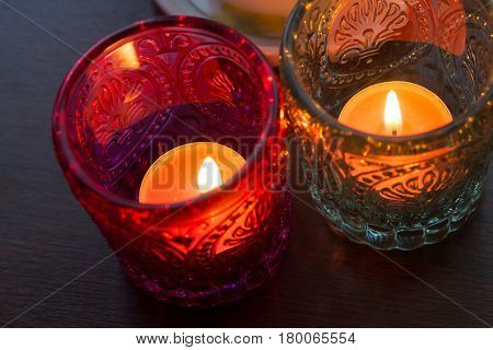 pink candle and light bule candle on a table .
