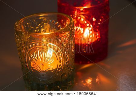 pink candle and light bule candle on a table .