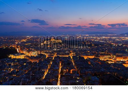panoramic cityscape of Athens with Acorpolis hill and sea at night, Greece