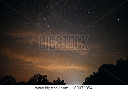 A Clear Night Sky With A Hill And Trees In The Foreground