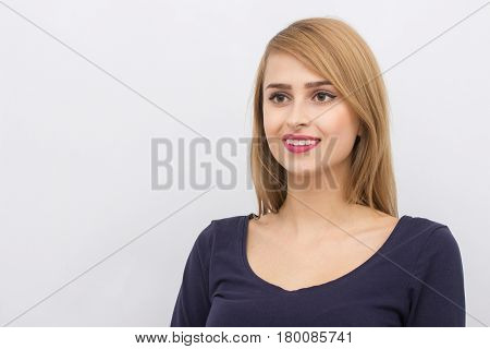Fashion portrait of a girl posing in bright, spacious studio with a gray background in a stylish comfortable and simple clothes. young girl with clean skin and perfect face